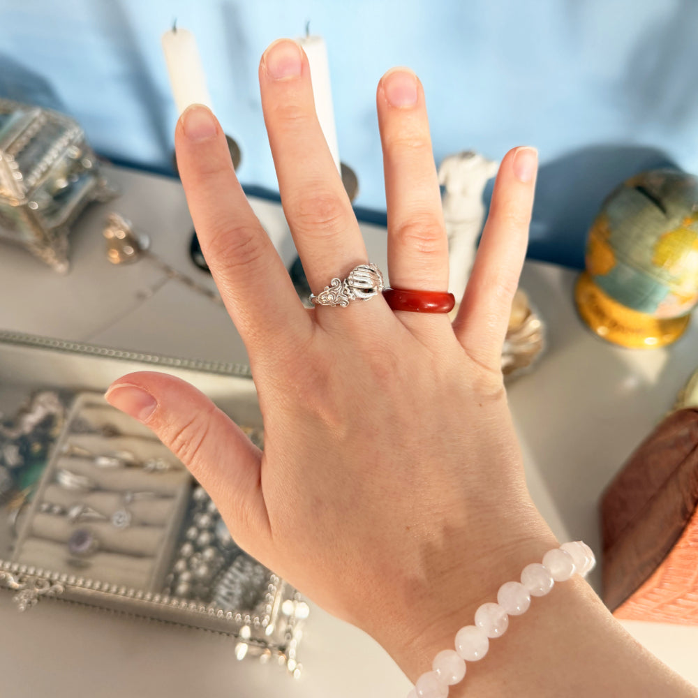 Hand wearing a silver ring with a red stone. Stone rings are on my jewelry wishlist.